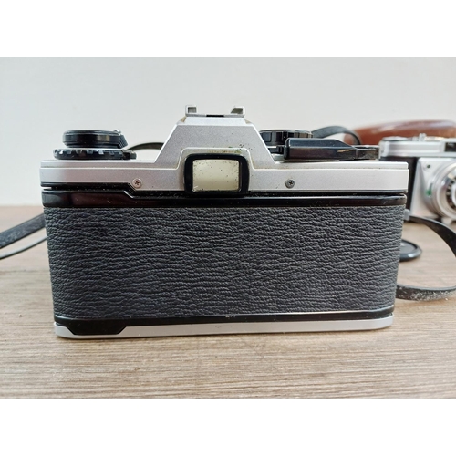 191 - Two 35mm cameras, one Olympus OM10 35mm SLR fitted with Zuiko MC Auto-S 1:1.8 50mm lens and one case... 