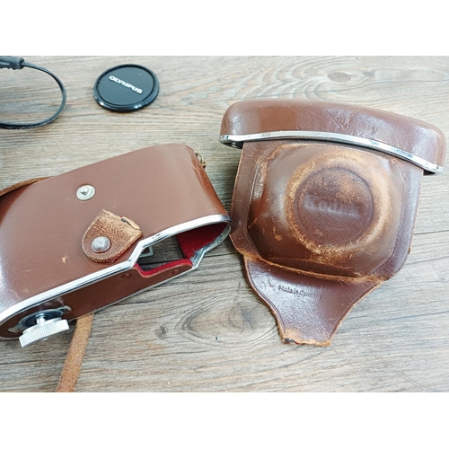 191 - Two 35mm cameras, one Olympus OM10 35mm SLR fitted with Zuiko MC Auto-S 1:1.8 50mm lens and one case... 