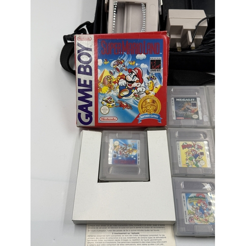 214 - A Nintendo Game Boy handheld game console with accessories and games to include Super Mario Land, Su... 