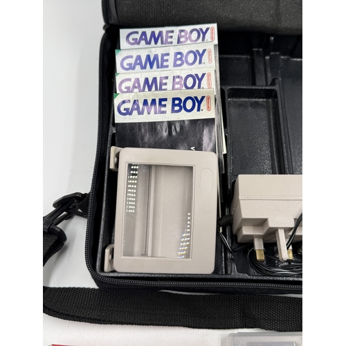 214 - A Nintendo Game Boy handheld game console with accessories and games to include Super Mario Land, Su... 