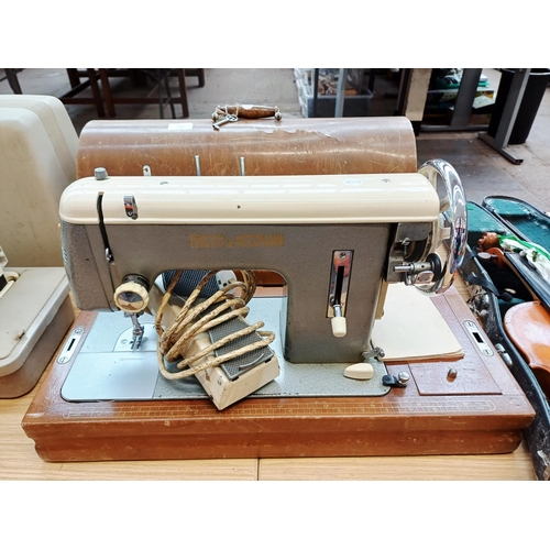 366 - A cased Frister & Rossmann electric sewing machine with foot pedal, attachments, accessories and ins... 