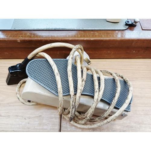 366 - A cased Frister & Rossmann electric sewing machine with foot pedal, attachments, accessories and ins... 