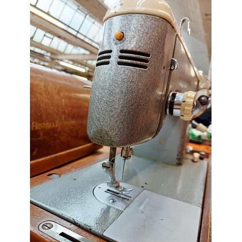366 - A cased Frister & Rossmann electric sewing machine with foot pedal, attachments, accessories and ins... 
