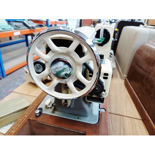 366 - A cased Frister & Rossmann electric sewing machine with foot pedal, attachments, accessories and ins... 