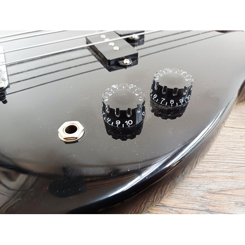 369 - A cased Encore short-scale electric bass guitar with EzetunE MT-1000 electronic chromatic tuner and ... 