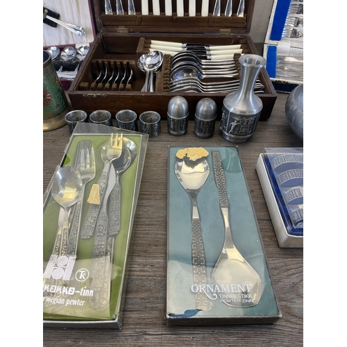 260 - Four boxes containing metalware, three containing cutlery and one containing pewter ware to include ... 