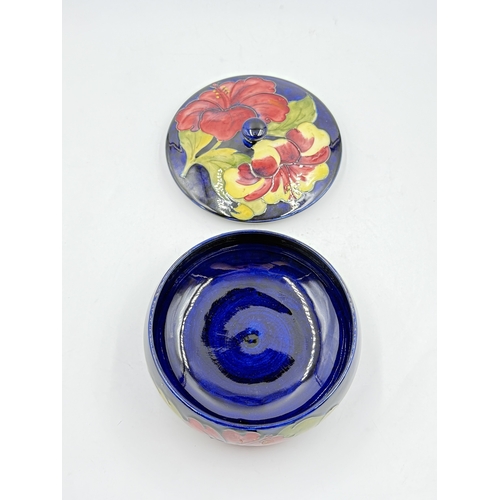 172 - A Moorcroft Hibiscus pattern circular lidded bowl - approx. 9cm high x 17cm diameter