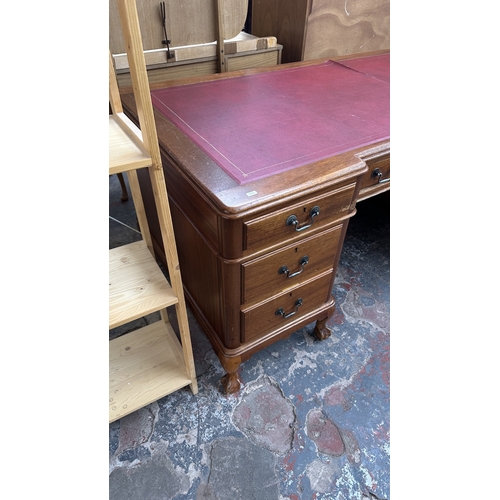 10 - A 19th century style mahogany pedestal writing desk with red leather top and ball and claw supports ... 