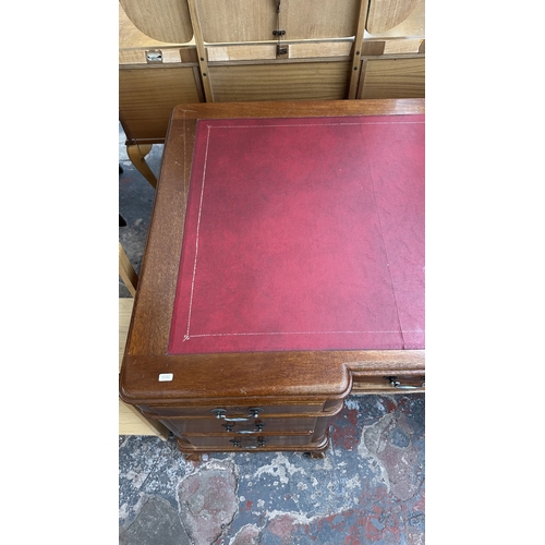 10 - A 19th century style mahogany pedestal writing desk with red leather top and ball and claw supports ... 