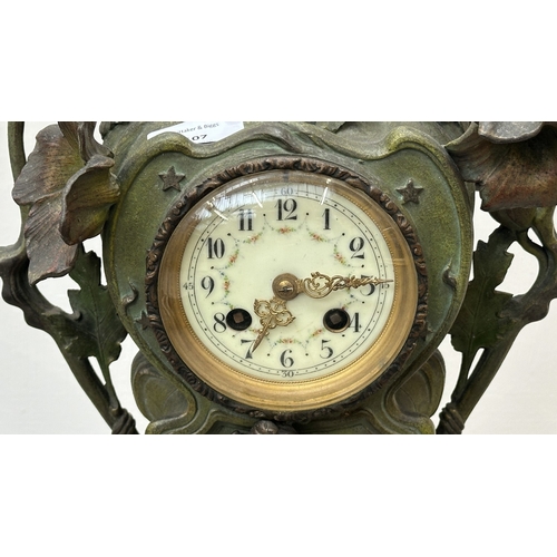 107 - An Art Nouveau French cast metal figural mantel clock with hand painted enamel face and foliate deco... 