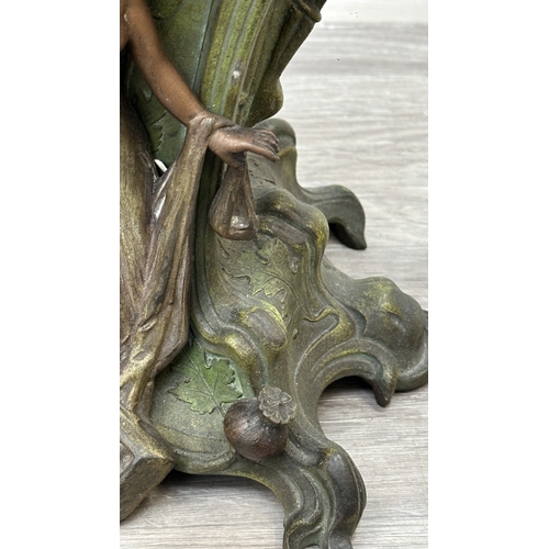 107 - An Art Nouveau French cast metal figural mantel clock with hand painted enamel face and foliate deco... 