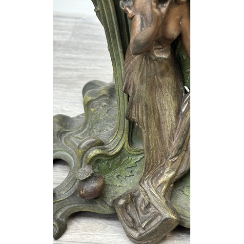 107 - An Art Nouveau French cast metal figural mantel clock with hand painted enamel face and foliate deco... 