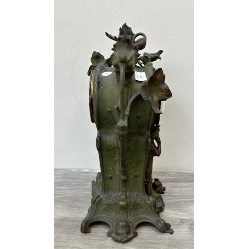 107 - An Art Nouveau French cast metal figural mantel clock with hand painted enamel face and foliate deco... 
