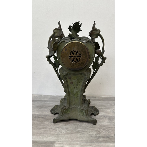 107 - An Art Nouveau French cast metal figural mantel clock with hand painted enamel face and foliate deco... 