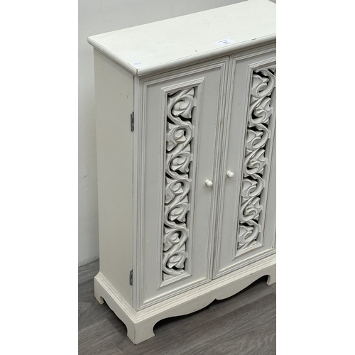 111 - A modern white painted two door cabinet with foliate design - approx. 68.5cm high x 45cm wide x 19cm... 