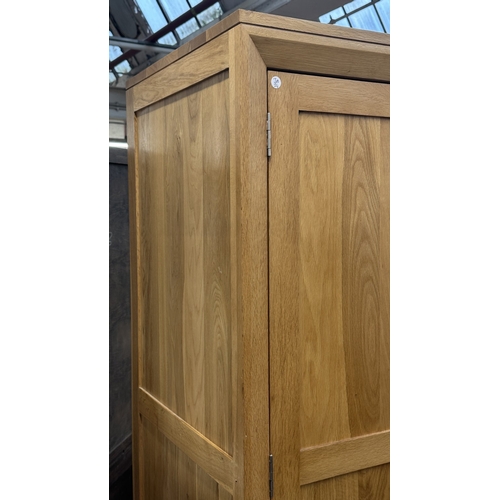 12 - A modern oak double wardrobe - approx. 194cm high x 118cm wide x 60cm deep