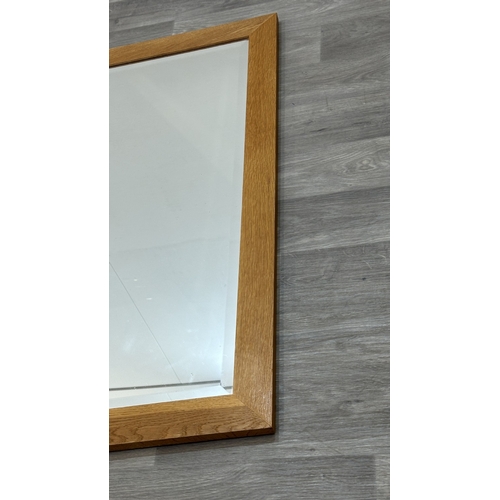 123 - A modern oak framed bevelled edge wall mirror - approx. 115cm high x 89cm wide