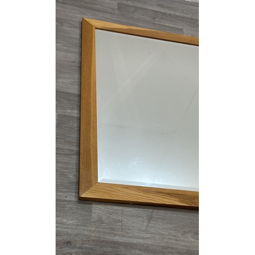 123 - A modern oak framed bevelled edge wall mirror - approx. 115cm high x 89cm wide