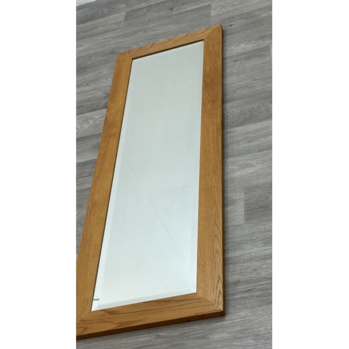 124 - A modern oak framed bevelled edge wall mirror - approx. 135cm high x 43cm wide