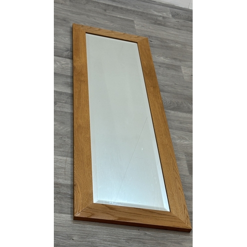 124 - A modern oak framed bevelled edge wall mirror - approx. 135cm high x 43cm wide