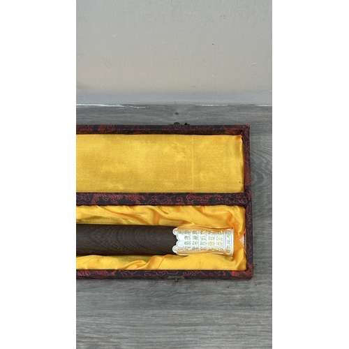 128 - A boxed Chinese decorative Tai Chi Jian engraved sword with wooden scabbard - approx. 81cm long