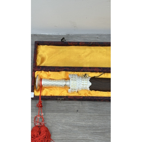 128 - A boxed Chinese decorative Tai Chi Jian engraved sword with wooden scabbard - approx. 81cm long