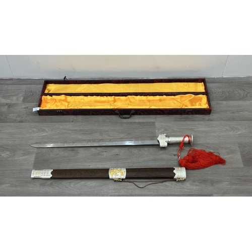 128 - A boxed Chinese decorative Tai Chi Jian engraved sword with wooden scabbard - approx. 81cm long