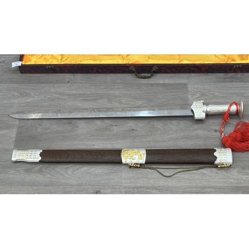 128 - A boxed Chinese decorative Tai Chi Jian engraved sword with wooden scabbard - approx. 81cm long