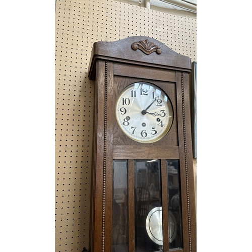 133 - An early 20th century oak cased Westminster chime wall clock with pendulum and key - approx. 80cm hi... 