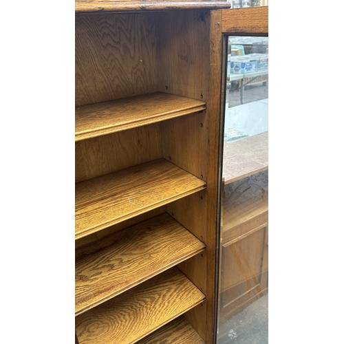 13B - A 1920s/30s oak glazed bookcase on baluster supports - approx. 149cm high x 95cm wide x 30cm deep