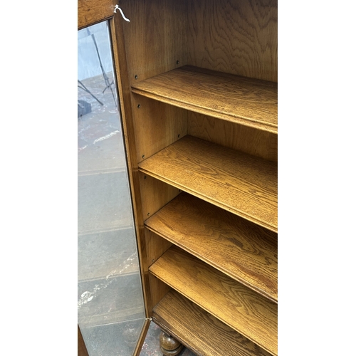 13B - A 1920s/30s oak glazed bookcase on baluster supports - approx. 149cm high x 95cm wide x 30cm deep