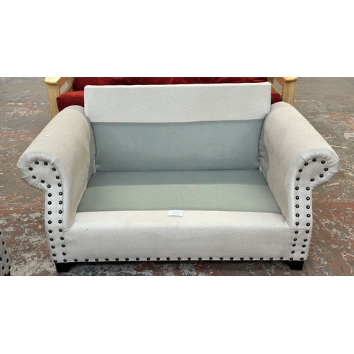 16 - A modern grey fabric upholstered and metal studded two piece lounge suite comprising two seater sofa... 