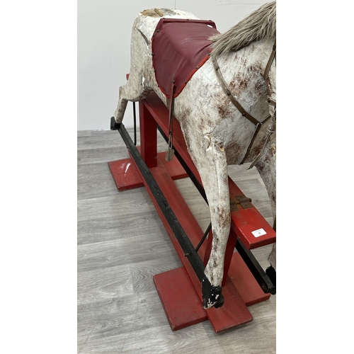 22 - An early 20th century painted plaster and carved wooden rocking horse - approx. 106cm high x 41cm wi... 