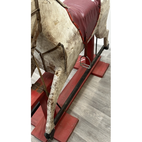 22 - An early 20th century painted plaster and carved wooden rocking horse - approx. 106cm high x 41cm wi... 
