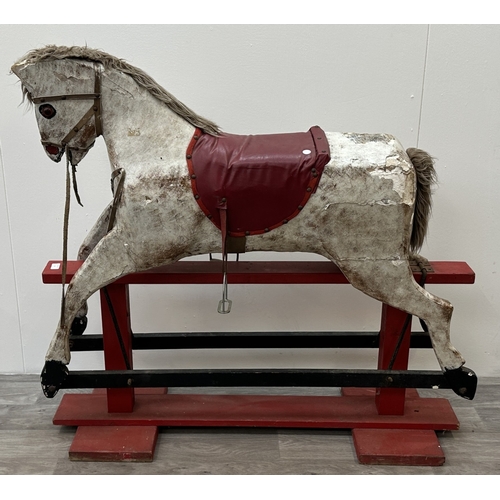 22 - An early 20th century painted plaster and carved wooden rocking horse - approx. 106cm high x 41cm wi... 
