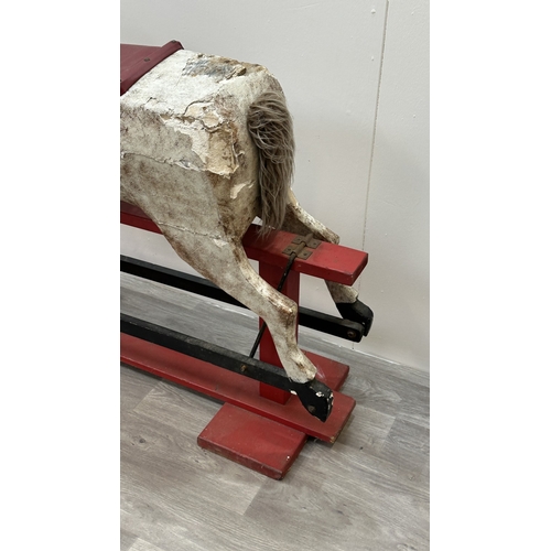 22 - An early 20th century painted plaster and carved wooden rocking horse - approx. 106cm high x 41cm wi... 