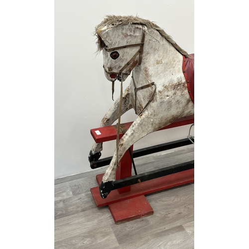 22 - An early 20th century painted plaster and carved wooden rocking horse - approx. 106cm high x 41cm wi... 