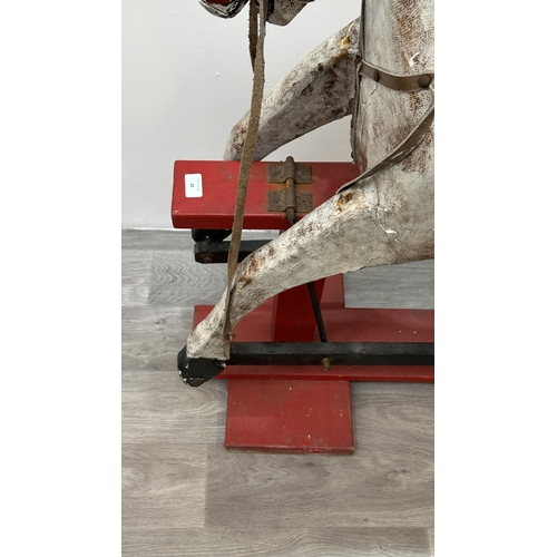 22 - An early 20th century painted plaster and carved wooden rocking horse - approx. 106cm high x 41cm wi... 