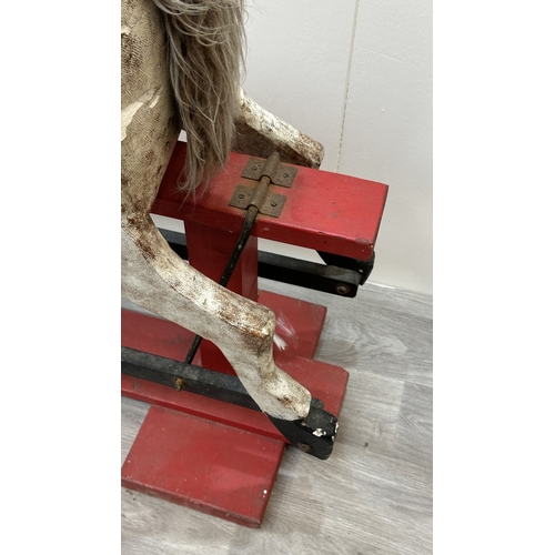 22 - An early 20th century painted plaster and carved wooden rocking horse - approx. 106cm high x 41cm wi... 