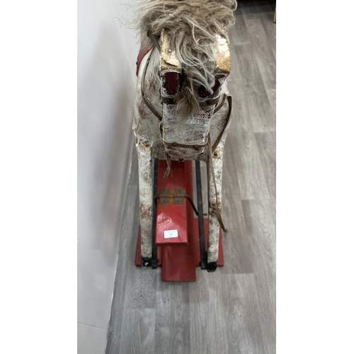 22 - An early 20th century painted plaster and carved wooden rocking horse - approx. 106cm high x 41cm wi... 