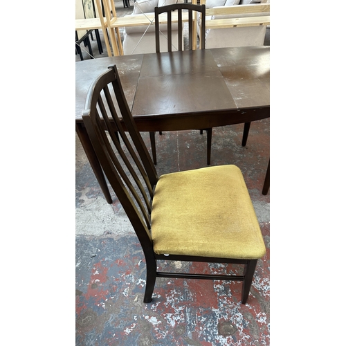23 - A mid 20th century stained teak extending dining table and four fabric upholstered chairs - approx. ... 