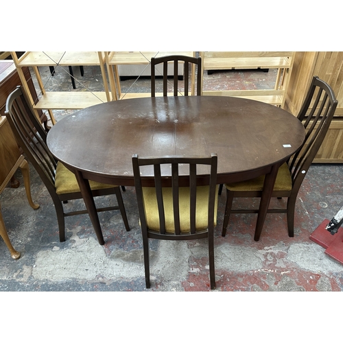 23 - A mid 20th century stained teak extending dining table and four fabric upholstered chairs - approx. ... 