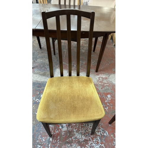 23 - A mid 20th century stained teak extending dining table and four fabric upholstered chairs - approx. ... 