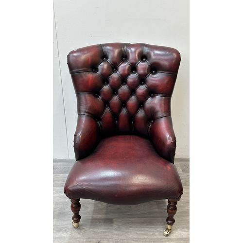 37A - A 19th century style oxblood leather Chesterfield armchair on turned beech supports and brass castor... 