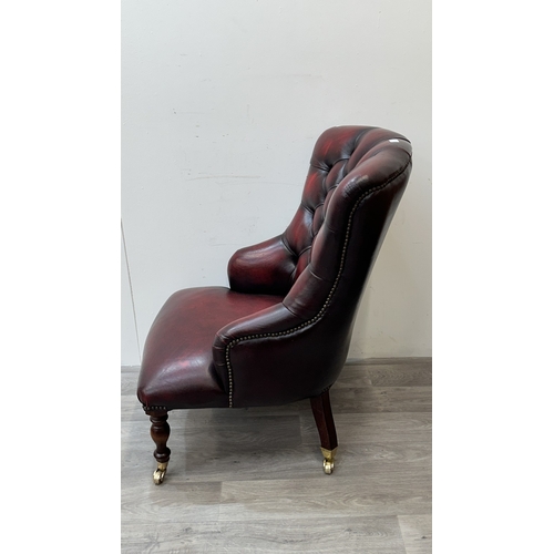 37A - A 19th century style oxblood leather Chesterfield armchair on turned beech supports and brass castor... 