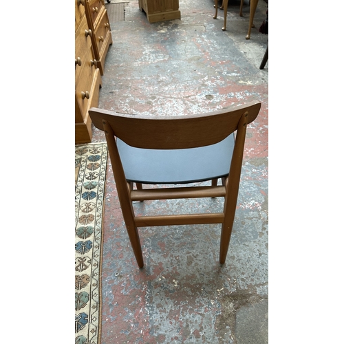 37C - A mid 20th century Elliotts of Newbury teak circular drop leaf dining table and four black vinyl cha... 