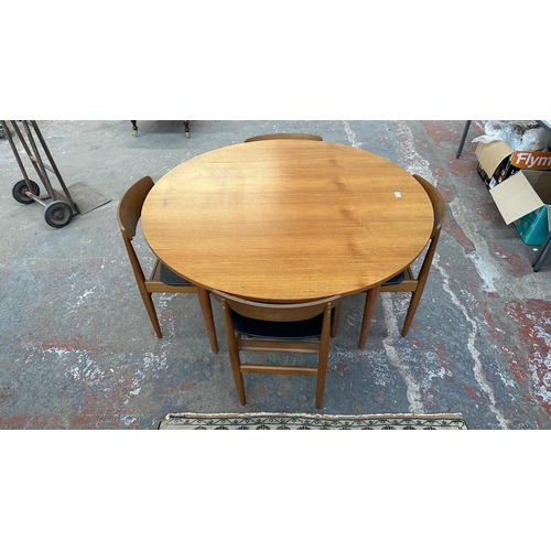 37C - A mid 20th century Elliotts of Newbury teak circular drop leaf dining table and four black vinyl cha... 