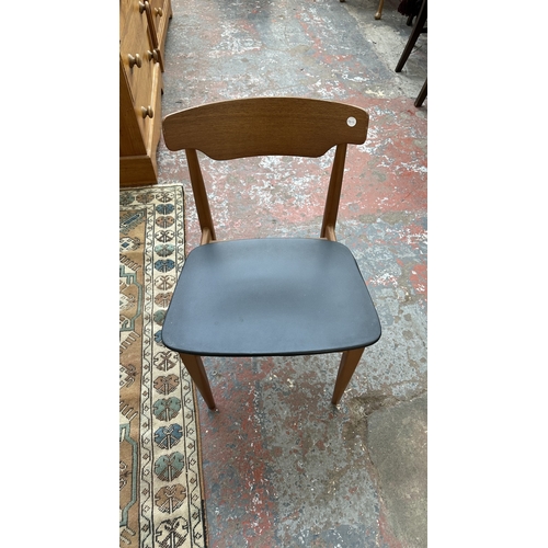 37C - A mid 20th century Elliotts of Newbury teak circular drop leaf dining table and four black vinyl cha... 