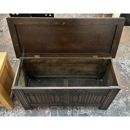 4 - A 17th century style carved oak linenfold blanket box - approx. 52cm high x 99cm wide x 40cm deep