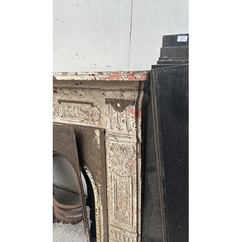 48 - A Victorian white painted cast iron fire surround with two inserts - approx. 126cm high x 136cm wide... 